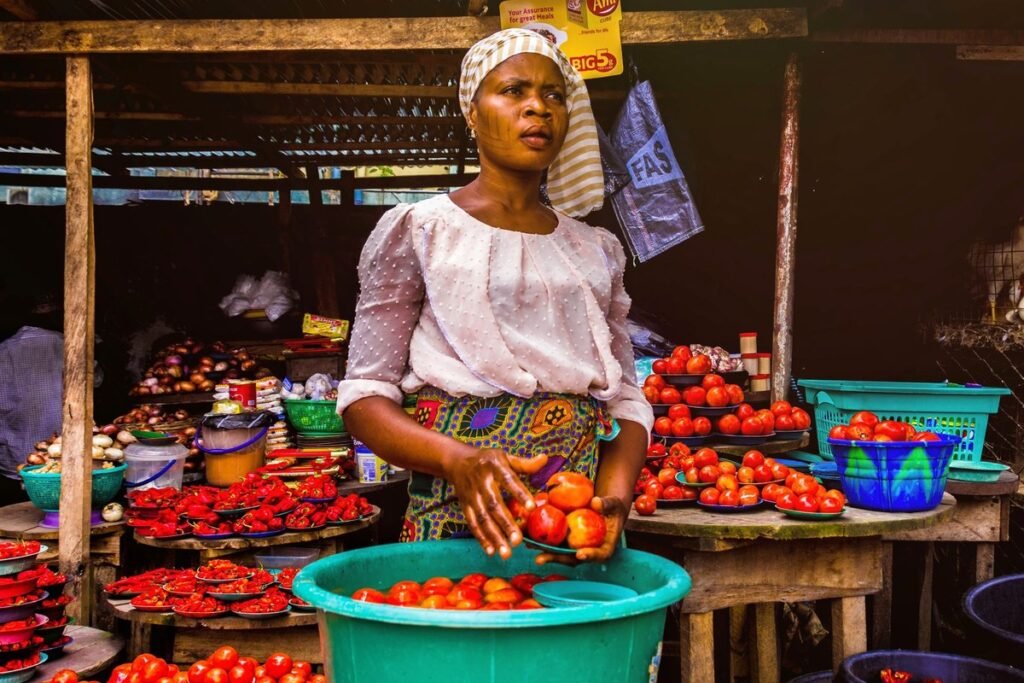 Woman selling fresh tomatoes at an outdoor market stall