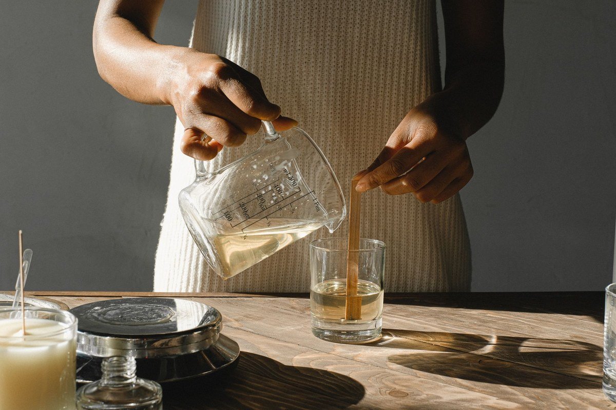 How to calculate product cost: a woman pouring melted wax into a mould while making handmade candles.